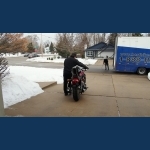 Curtis taking the bike down the driveway for the last time.